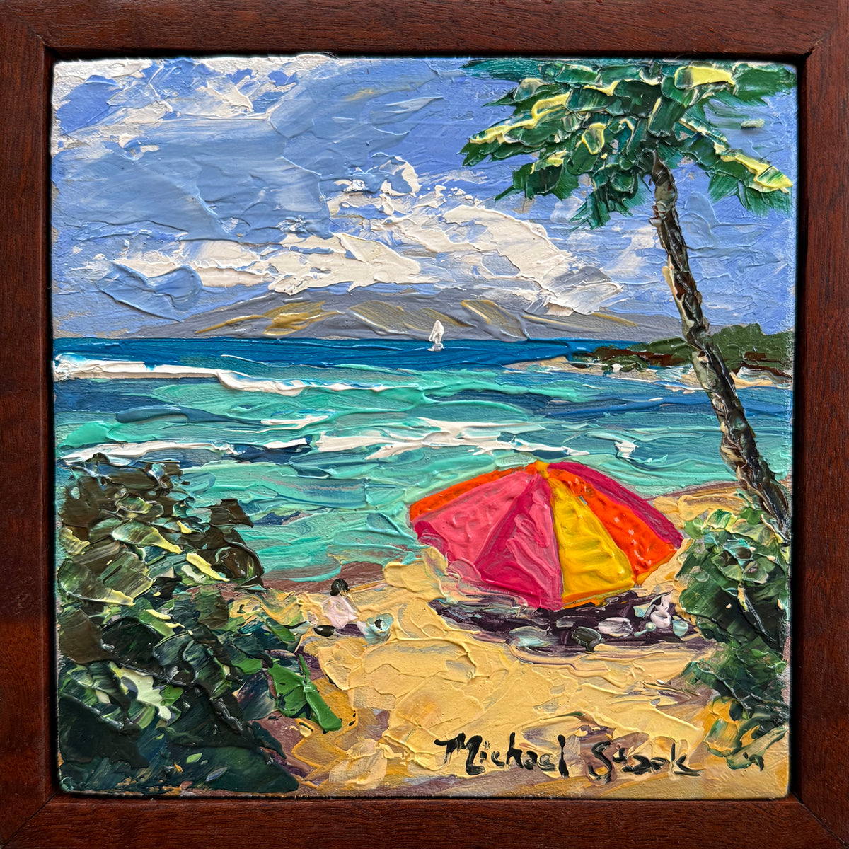 A framed square Hawaii oil painting depicting a tropical Maui beach scene in Kapalua with turquoise ocean waves, a sandy shore, a red and yellow beach umbrella, green palm foliage, and a dark brown wooden frame. The artist's signature 'Michael Stark' is visible in the bottom right corner.